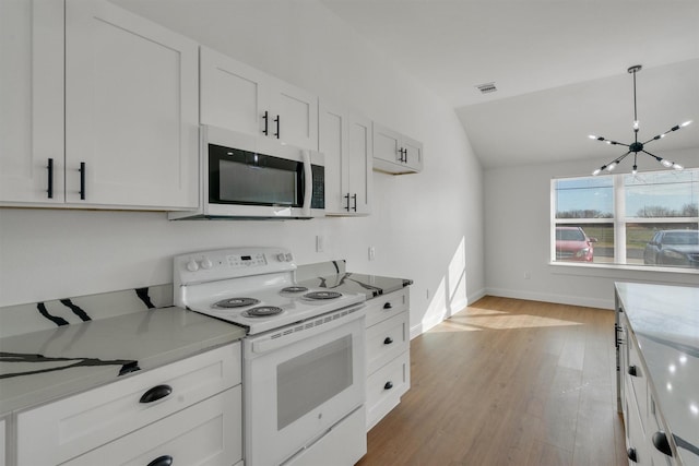 kitchen with decorative light fixtures, light wood-type flooring, white appliances, lofted ceiling, and white cabinets