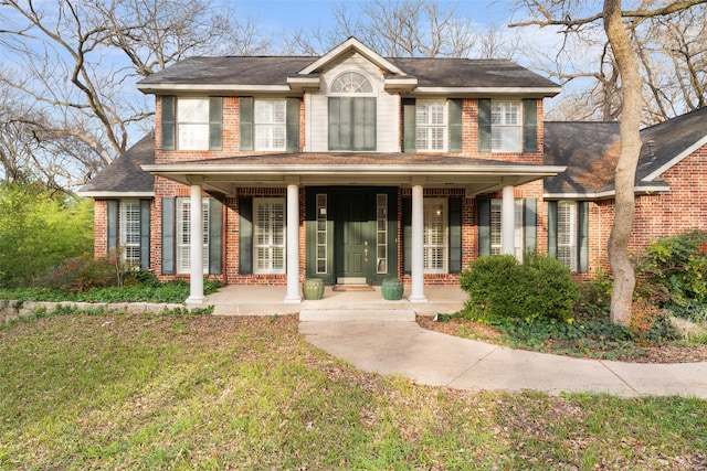 view of front of home with a porch and a front yard