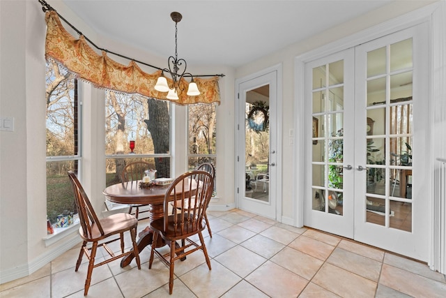 dining area featuring a chandelier, french doors, and light tile patterned flooring