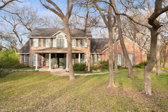 colonial home featuring a front lawn and a porch