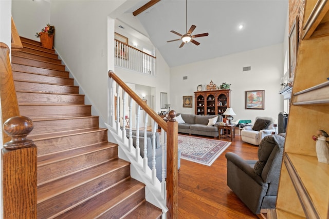 stairway with high vaulted ceiling, hardwood / wood-style flooring, and ceiling fan