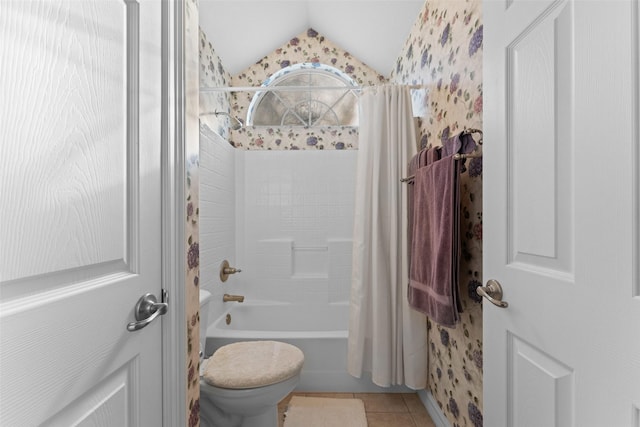 bathroom featuring toilet, vaulted ceiling, tile patterned floors, and shower / bath combo with shower curtain