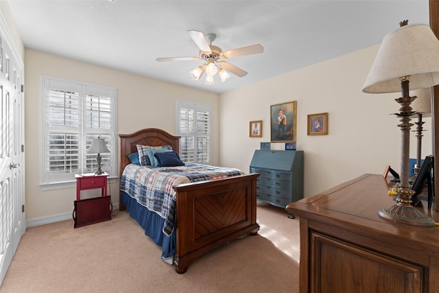 bedroom with ceiling fan, a closet, and light carpet