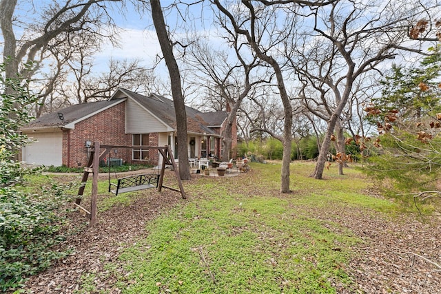 view of yard featuring a garage and a patio