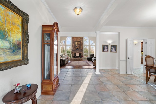 entryway featuring a brick fireplace, crown molding, and decorative columns