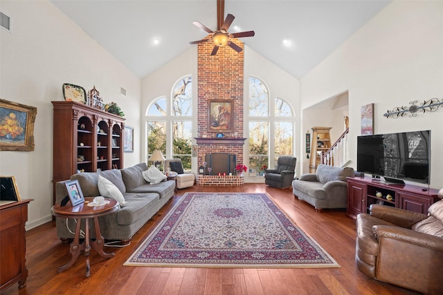 living room featuring ceiling fan, a fireplace, hardwood / wood-style flooring, and high vaulted ceiling