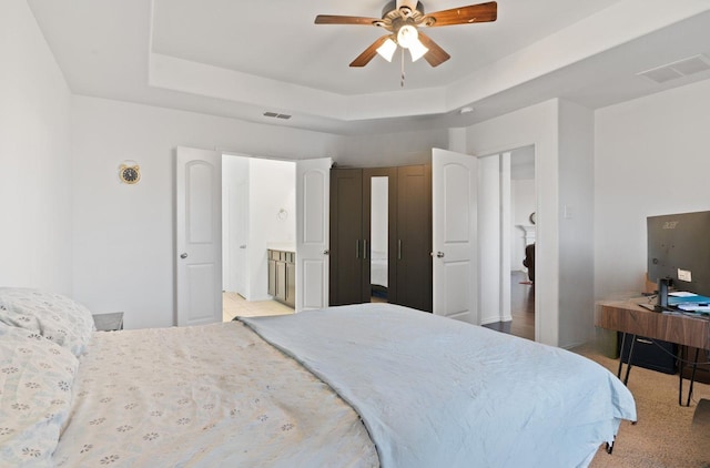 bedroom with ceiling fan and a raised ceiling