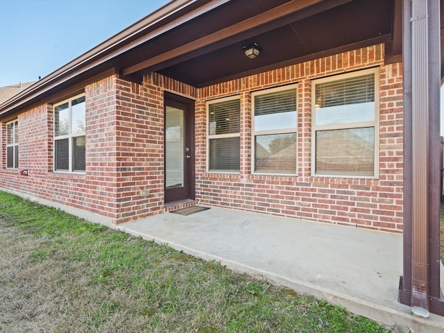 entrance to property featuring a patio area and a yard