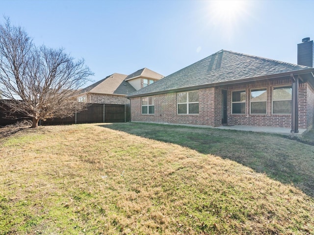 rear view of house featuring a lawn