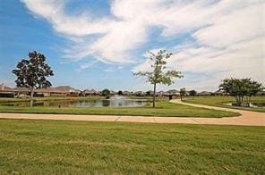 view of home's community with a lawn and a water view