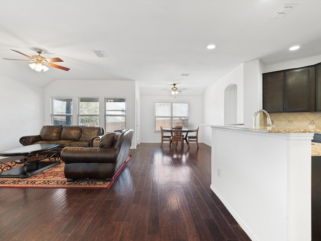 living room featuring ceiling fan, dark wood-type flooring, sink, and vaulted ceiling