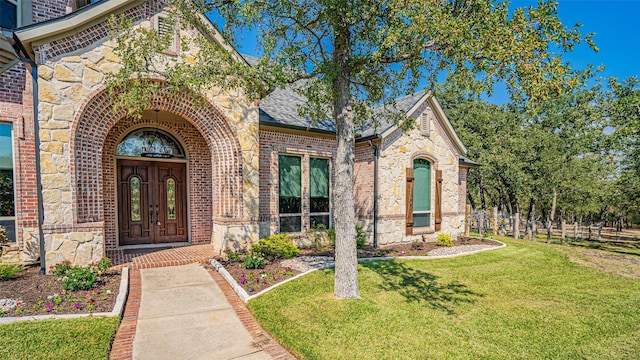 view of exterior entry featuring a lawn