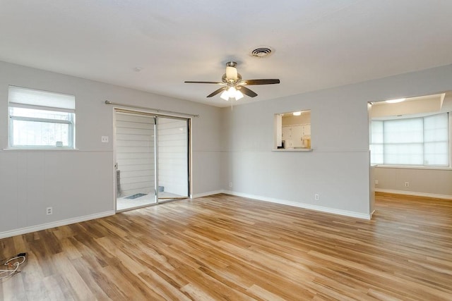 empty room with ceiling fan, light hardwood / wood-style flooring, and a healthy amount of sunlight