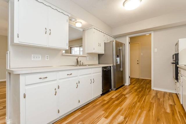 kitchen featuring black dishwasher, high end refrigerator, white cabinets, light hardwood / wood-style flooring, and sink