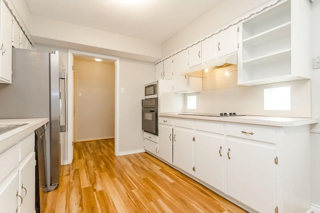 kitchen featuring light hardwood / wood-style flooring, white cabinets, and black appliances