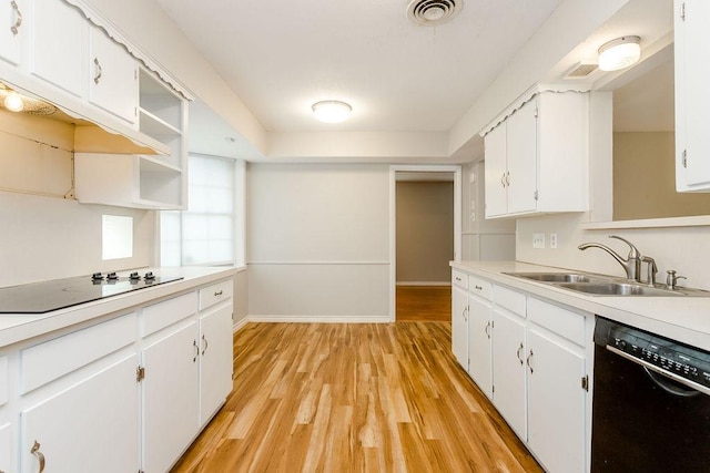 kitchen with black appliances, white cabinets, sink, and light hardwood / wood-style floors