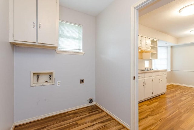 clothes washing area with cabinets, electric dryer hookup, hookup for a washing machine, and light hardwood / wood-style floors