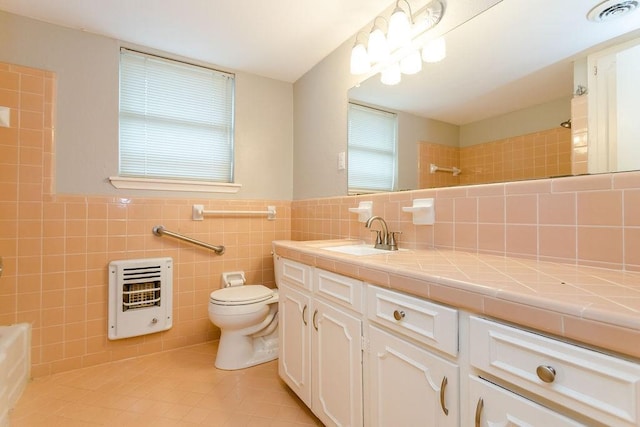 bathroom featuring toilet, vanity, tile walls, tile patterned flooring, and heating unit