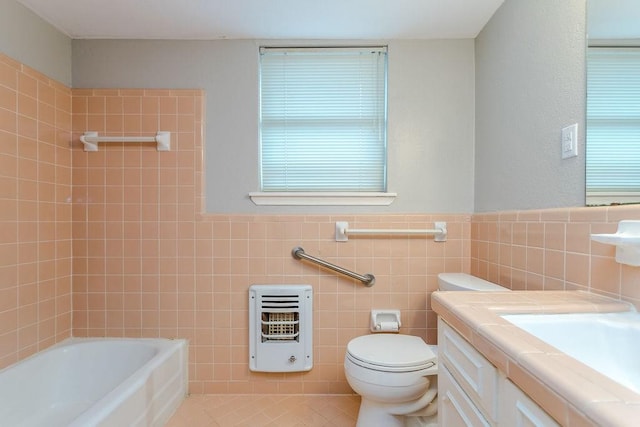 bathroom with vanity, tile walls, tile patterned floors, a tub, and heating unit