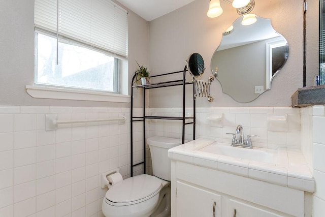 bathroom featuring tile walls, toilet, and vanity