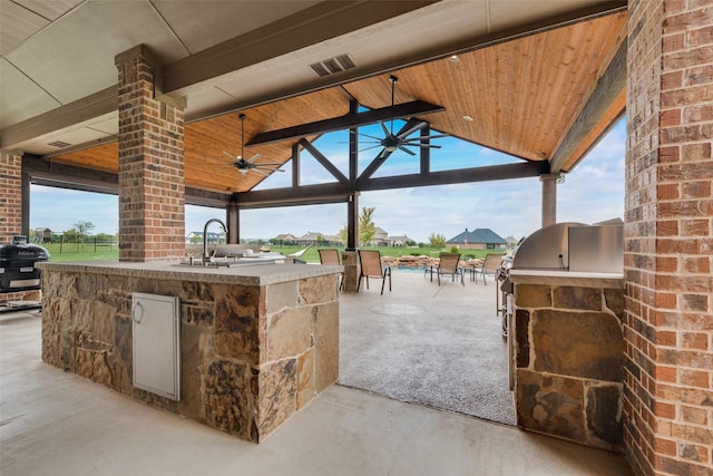 view of patio / terrace featuring ceiling fan, an outdoor kitchen, a gazebo, and area for grilling