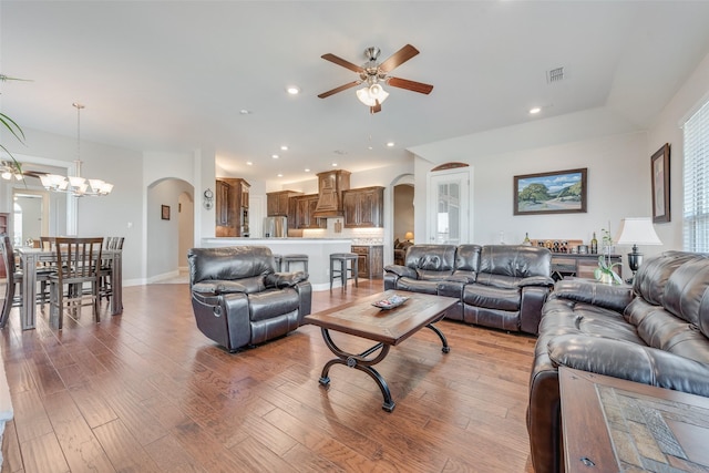 living room featuring hardwood / wood-style flooring and ceiling fan with notable chandelier