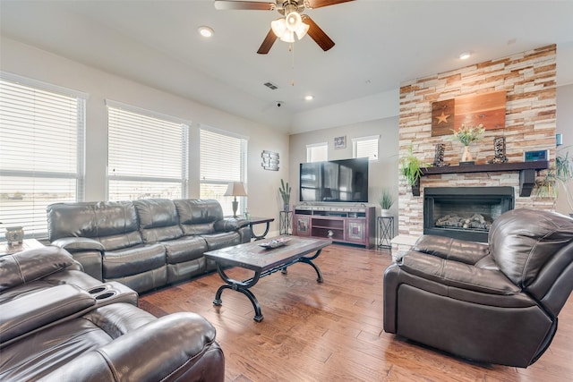 living room with ceiling fan, wood-type flooring, a fireplace, and plenty of natural light