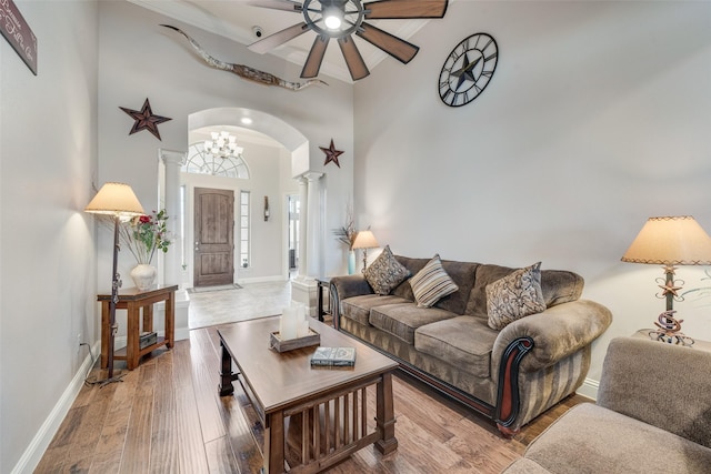 living room featuring ceiling fan, hardwood / wood-style floors, a high ceiling, and ornate columns