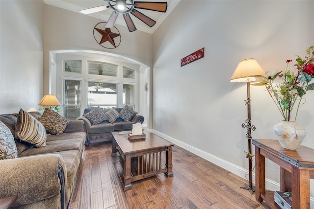 living room featuring hardwood / wood-style flooring, a high ceiling, and ceiling fan