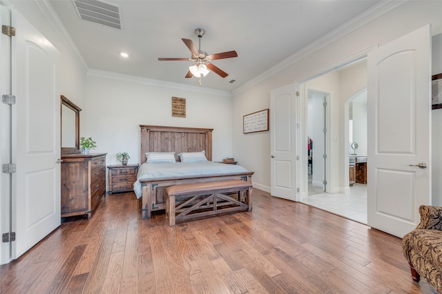 bedroom with ceiling fan, crown molding, ensuite bathroom, and hardwood / wood-style flooring