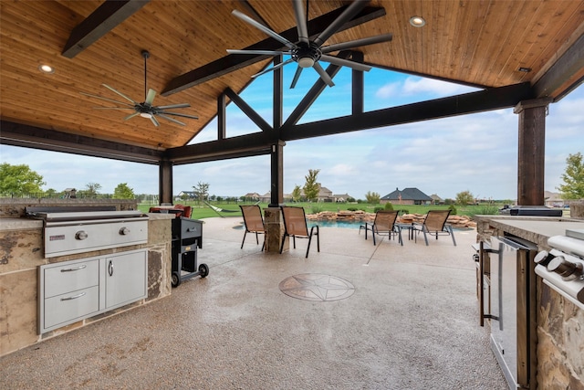 view of patio / terrace featuring ceiling fan, exterior kitchen, an outdoor bar, and area for grilling