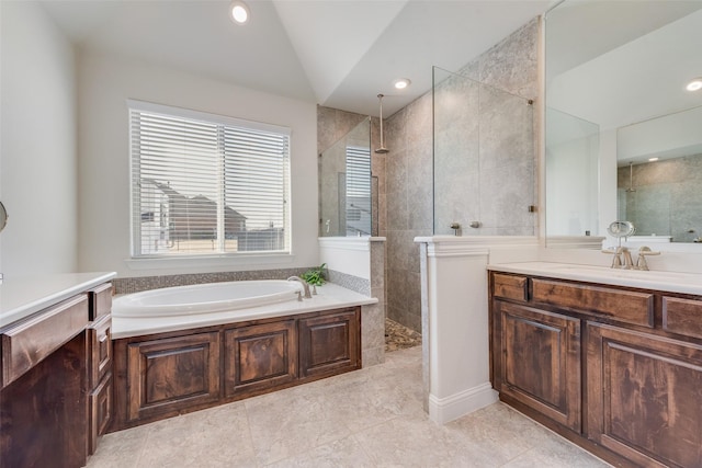 bathroom with shower with separate bathtub, vanity, and vaulted ceiling