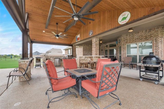 view of patio featuring ceiling fan, exterior bar, and area for grilling