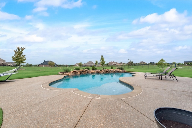 view of pool with a lawn and a patio