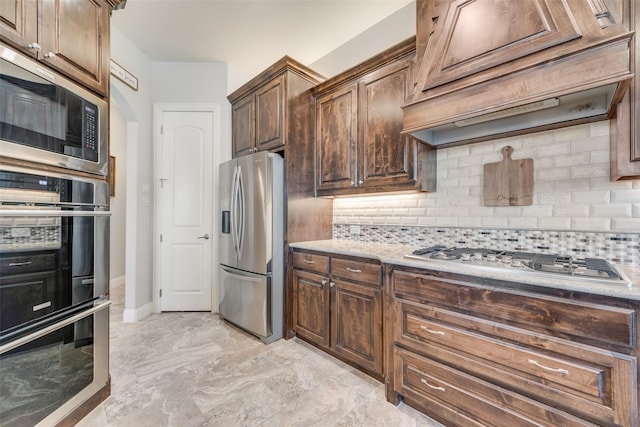 kitchen featuring custom range hood, stainless steel appliances, and tasteful backsplash