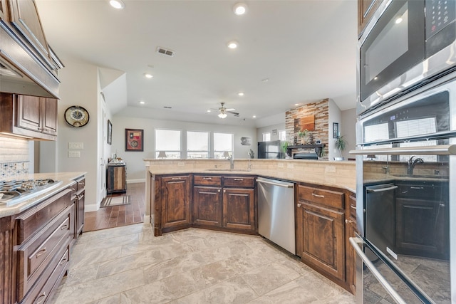 kitchen featuring ceiling fan, sink, stainless steel appliances, and custom range hood