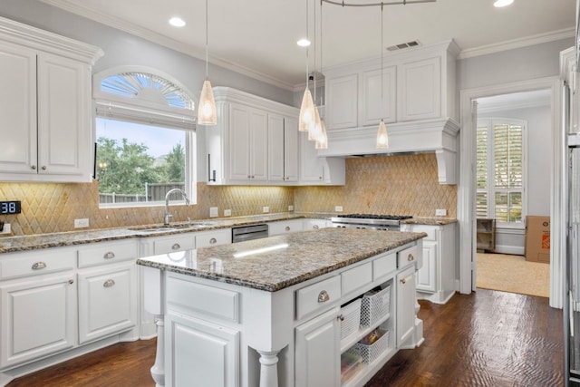 kitchen featuring white cabinets, sink, and a kitchen island