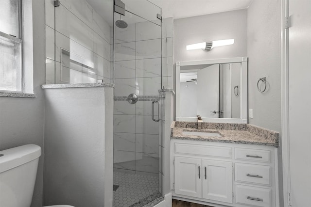 bathroom with toilet, walk in shower, and vanity