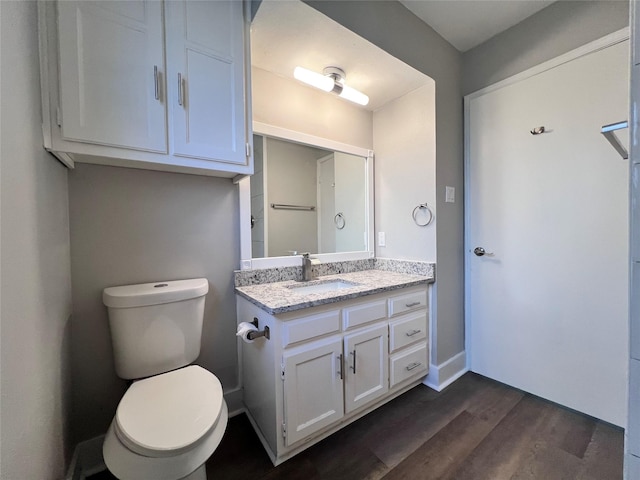 bathroom with toilet, hardwood / wood-style flooring, and vanity