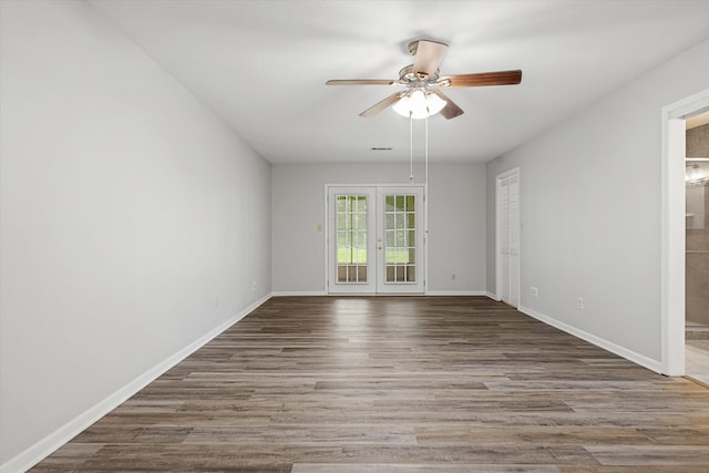 empty room with ceiling fan, french doors, and dark wood-type flooring