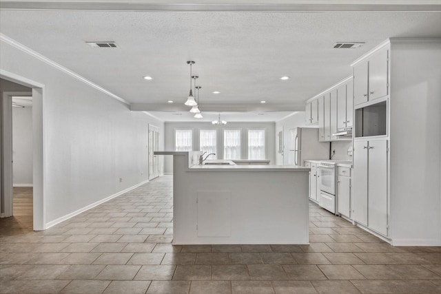 kitchen featuring white appliances, decorative light fixtures, white cabinetry, sink, and a center island with sink