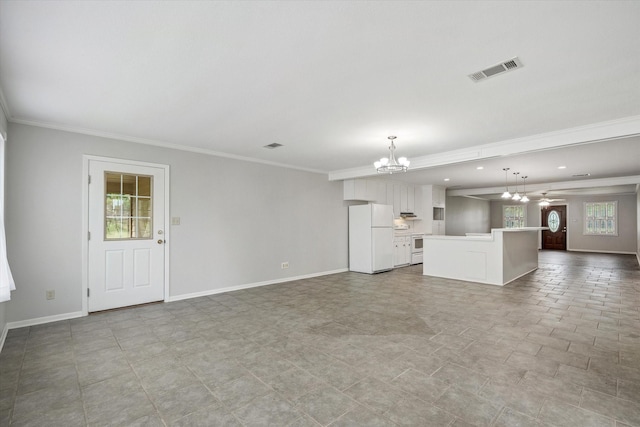 unfurnished living room with ornamental molding and an inviting chandelier