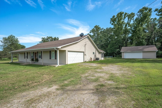 view of home's exterior featuring covered porch, a garage, an outbuilding, and a lawn