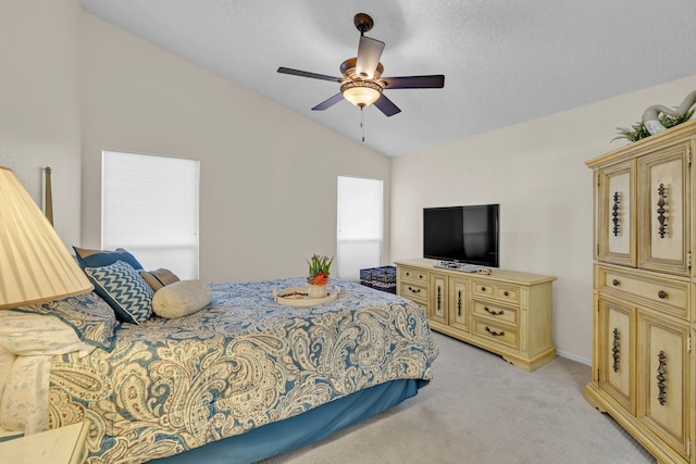 carpeted bedroom with vaulted ceiling, ceiling fan, and a textured ceiling