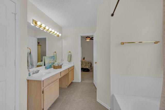 bathroom featuring ceiling fan, vanity, tile patterned flooring, a textured ceiling, and a washtub