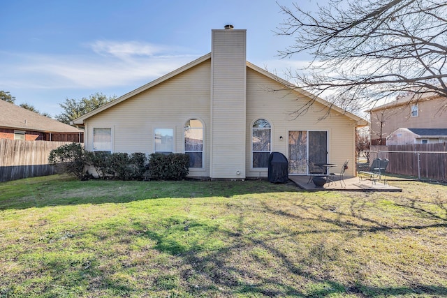 back of house with a lawn and a patio