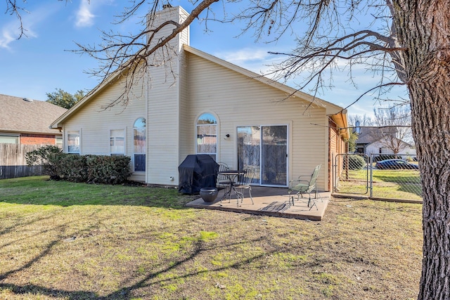 back of house featuring a lawn and a patio area