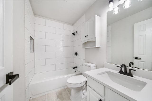 full bathroom featuring tiled shower / bath combo, vanity, and toilet