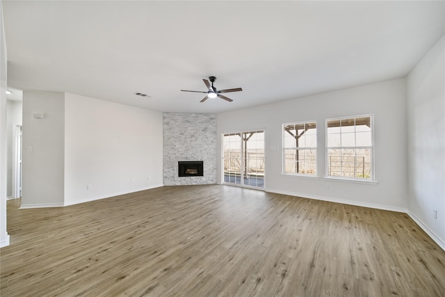 unfurnished living room with ceiling fan, light wood-type flooring, and a fireplace