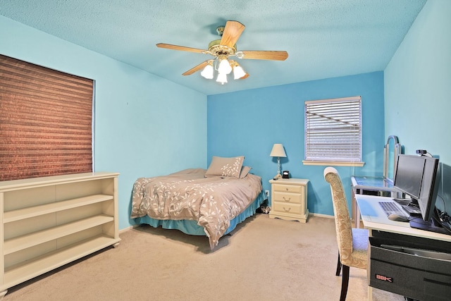 carpeted bedroom featuring ceiling fan and a textured ceiling